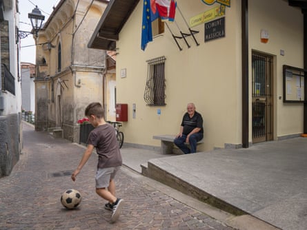 Renzo Albertini, mayor of Massiola in Piedmont, Italy, watches one of the village’s children kicking a ball in the street