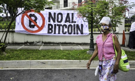 A woman walks by a banner reading “No to Bitcoin” during a demonstration in el salvador