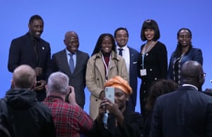 Six people on stage post for a photo