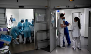 Staff members tend to a patient as others gather in a corridor in the Covid-19 intensive care unit at the Lyon-Sud Hospital in Pierre-Benite, near Lyon, central-eastern France.
