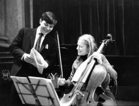 Kovacevich stands beside Jacqueline du Pré showing her a score as she sits with her cello.