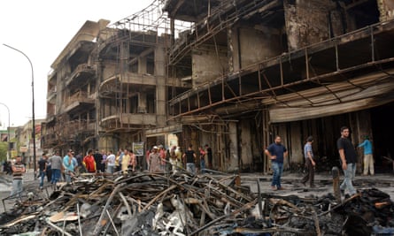 Iraqis gather at the site of the suicide car bombing in Karada