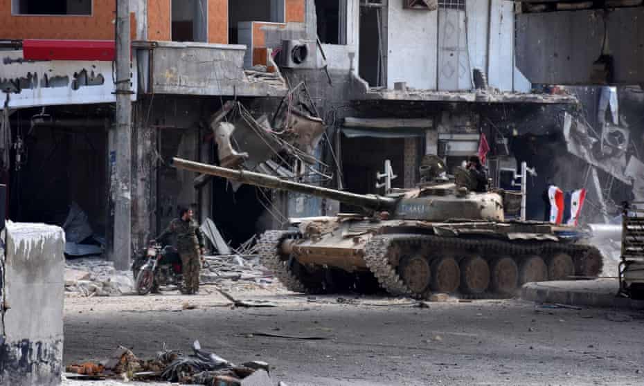 Syrian government troops patrol the al-Shaar neighbourhood after taking control of the area in Aleppo, Syria.