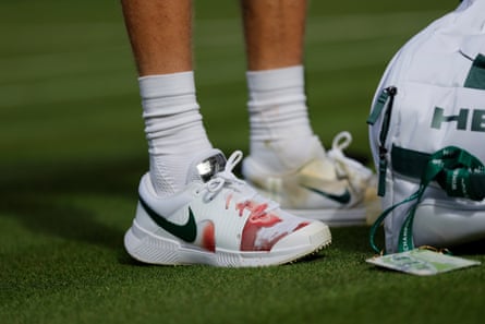 Blood is seen through Jannik Sinner's shoe