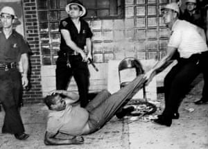 A man is arrested and beaten near where a police officer was fatally shot during the clashes.