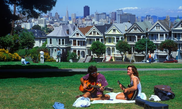 Two hippies play guitar in a San Francisco park.
