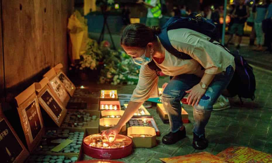 A pro-democracy supporter lights a candle at the Lennon Wall in Admiralty. After nine suicides linked to the protests, concern is growing about the mental health of the population.