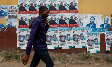 A man walks past electoral campaign posters in Lagos.