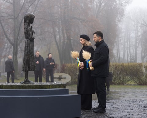 President Zelenskyy and his wife, Olena, at a monument to victims of the Holodomor famine in the form of a statue of a larger than life girl on a platform.