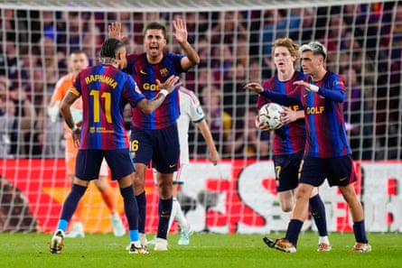 Raphinha celebrates with his teammates after scoring for Barcelona against Real Madrid.