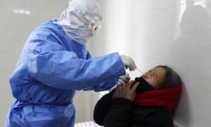 Un médico toma un hisopo de una mujer para detectar el virus Covid-19 en una clínica en el condado de Yinan, en la provincia oriental china de Shandong.
