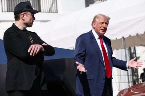 Tesla CEO Elon Musk (L) looks on as US President Donald Trump (R) speaks at the White House.