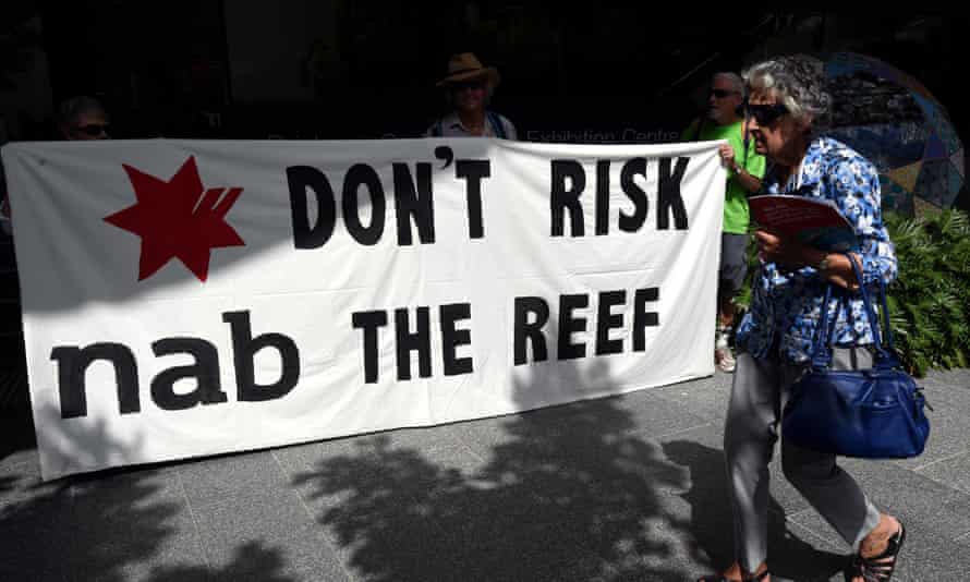 Protesters opposing the Abbot Point coal terminal hold up a sign as shareholders arrive for the National Australia Bank’s annual general meeting in Brisbane, Thursday, Dec. 18, 2014