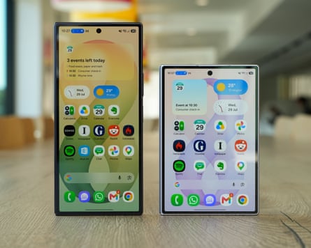 The Samsung Galaxy Z Fold 8 Ultra stood next to the Galaxy Z Fold 8 on a wooden table, each showing the home screen on their outside displays.