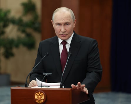 Putin stands behind a lectern