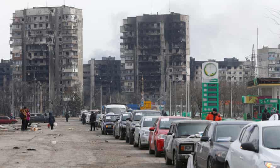 A view shows a line of cars near blocks of flats destroyed during Ukraine-Russia conflict, as evacuees leave the besieged port city of Mariupol, Ukraine March 17, 2022.