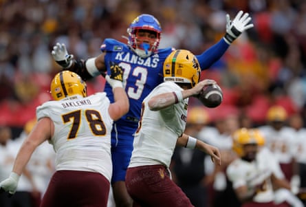 Arizona quarterback Cutter Boley tries to pass but is blocked by a leaping Leroy Harris III of Kansas.