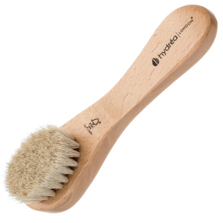 Face brush with long wooden handle stamped “FSC” and “Hydréa”