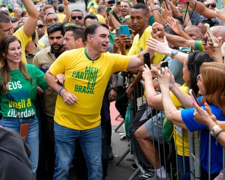 Jair Bolsonaro is cheered by supporters who lean over a barrier to take pictures of him