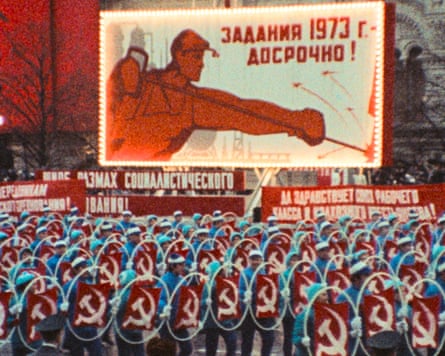 Still from Imperium that depicts a street parade of people holding up hammer and sickle flags