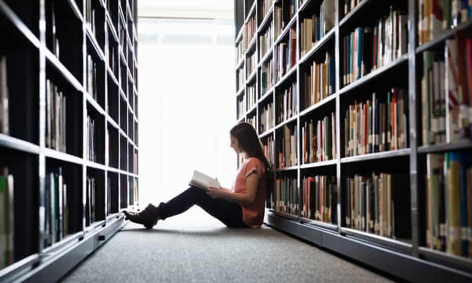 Woman sitting on library floor reading