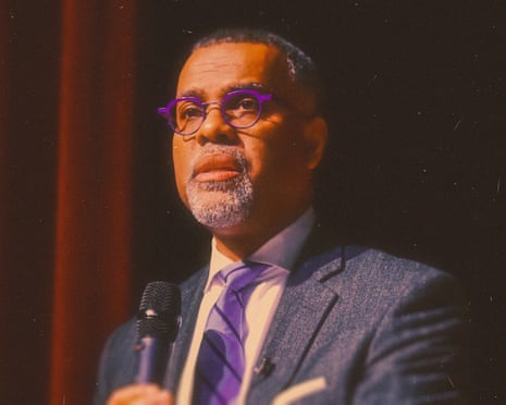 a man in a suit speaks into a microphone