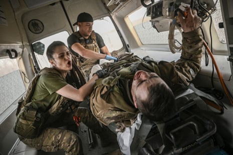 Ukrainian military paramedics evacuate a wounded serviceman from the front line near Bakhmut.