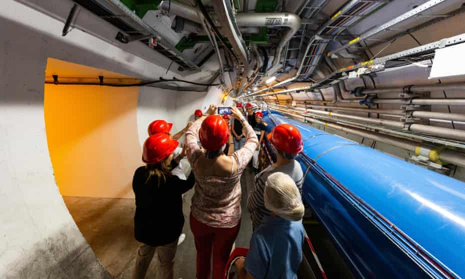 Bright minds: visitors take pictures at the Cern particle physics research facility. The Large Hadron Collider is 27km long.