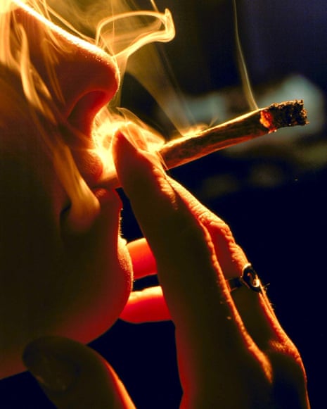 Closeup of person's mouth and nose as they take a drag on a joint