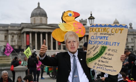 An Extinction Rebellion protester in a Boris Johnson mask