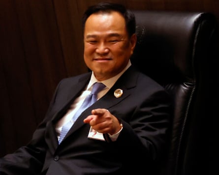 Anutin sitting in a leather chair smiling and pointing towards the camera.
