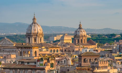 Eternal city: the city roofs and church domes of Rome at sunset.
