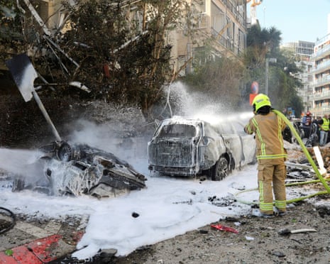 Israeli firefighters work to put out a fire after the attack