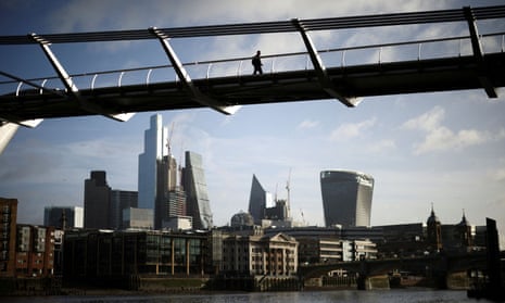 The City of London financial district is seen as a person walks over Millennium Bridge in London, Britain