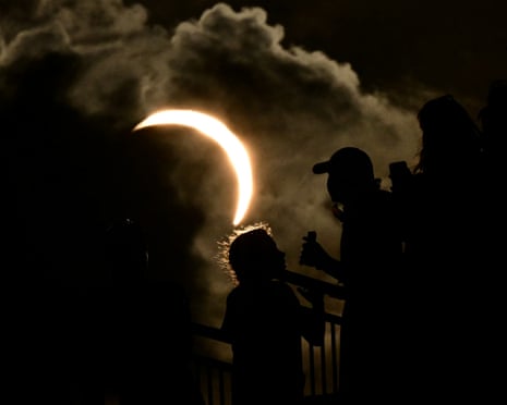 Members of the public watch the solar eclipse during the European Athletics Championships at Alexander Stadium in Birmingham.