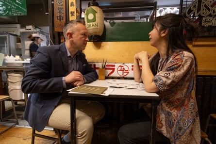David and Yung Yung talking while sitting opposite each other at a restaurant table