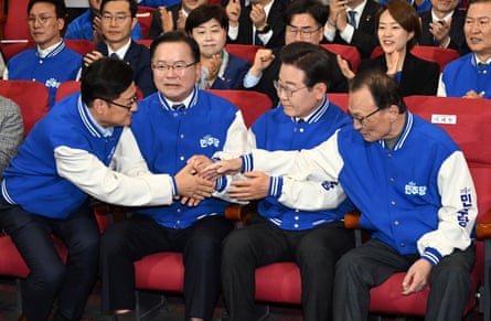 Officials of the main opposition Democratic party, including its leader Lee Jae-myung (second from right), react as TV exit polls emerge.