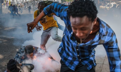 Students from the University of the Witwatersrand react to a police grenade during a protest against university fee increases.