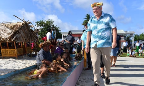 Children symbolically representing climate change greet Prime Minister Scott Morrison as he arrives for the Pacific Islands Forum in Tuvalu.