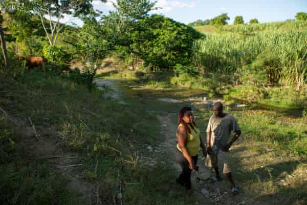 Marie Millande Tulmé, an epidemiologist, speaks with Reynald Louis Charles, a farmer, on the banks of the Meille river at the former UN base near Mirebalais