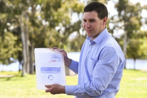 Liberal leader Alistair Coe holds a frozen rates bill during a press conference on Friday