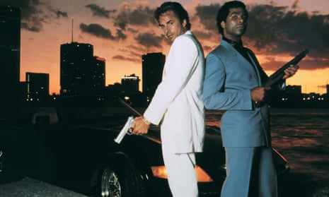 Don Johnson and Philip Michael Thomas holding firearms in front of a Ferrari