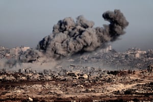 Gaza Strip. Smoke rises above the ruins of buildings, most flattened