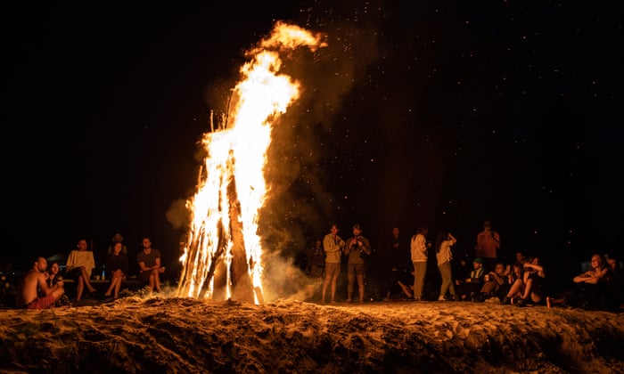 Young volunteers gather next to a bonfire at the end of the day after cleaning rubble from houses that were destroyed during the Russian invasion, not far from Ivanivka village, Chernihiv regionEPA/ROMAN PILIPEY
