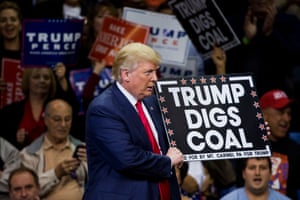 Donald Trump holds a 'Trump digs coal' sign