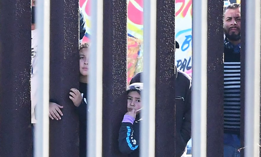 People gather and peer through fence
