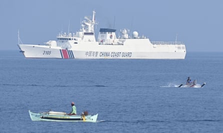 Philippine fishermen on wooden boats sailing past a Chinese coast guard ship near the Chinese-controlled Scarborough Shoal.