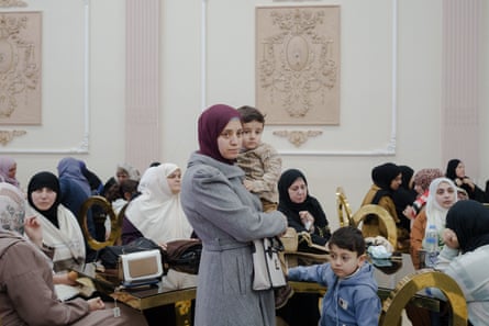 Palestinian families wait in a room.