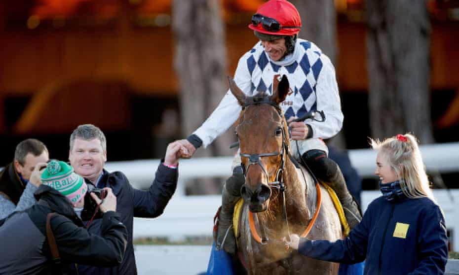 Davy Russell celebrates after winning on Galvin with trainer Gordon Elliott (left) and groom Carly Scott.