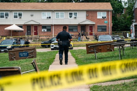A police officer walks in an area sectioned off by yellow crime scene tape.
